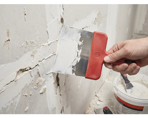 Handwerker verspachtelt eine Wand mit einem Spachtel