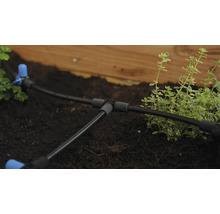 Bewässerungssystem mit Schläuchen und Verbindungsstücken im Gartenbeet