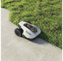 Mähroboter auf Rasen und Pflastersteinen