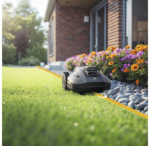Rasenmähroboter auf Rasen vor Haus
