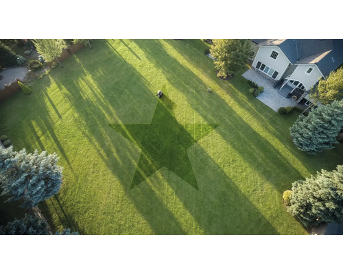 Luftaufnahme eines Gartens mit Rasenmäher und Sternmuster im Rasen