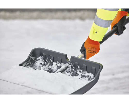 Person schippt Schnee mit einer Schneeschaufel