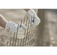 Person mit Arbeitshandschuhen, die eine Armierung verbindet