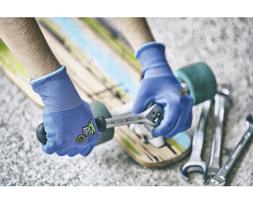 Person repariert Skateboard mit Schraubenschlüssel und Handschuhen