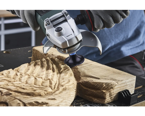 Eine Person verwendet einen Winkelschleifer zum Bearbeiten von Holz.