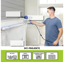 Mann benutzt Farbsprühgerät im Innenbereich für Heimwerkerprojekte.