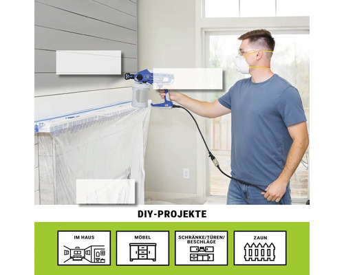 Mann benutzt Farbsprühgerät im Innenbereich für Heimwerkerprojekte.