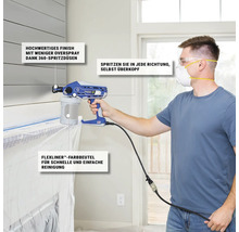 Ein Mann benutzt eine Farbspritzpistole der Marke Graco zum Malen in einem Innenraum.