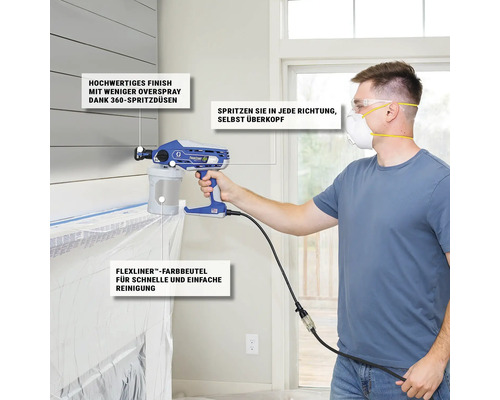 Ein Mann benutzt eine Farbspritzpistole der Marke Graco zum Malen in einem Innenraum.