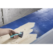 Eine Person verwendet einen Farbverteiler zum Auftragen von Farbe auf Holz