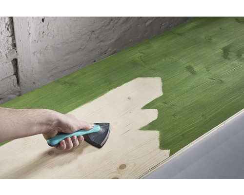 Ein Holzbrett wird mit einem Anstreicherwerkzeug gestrichen.