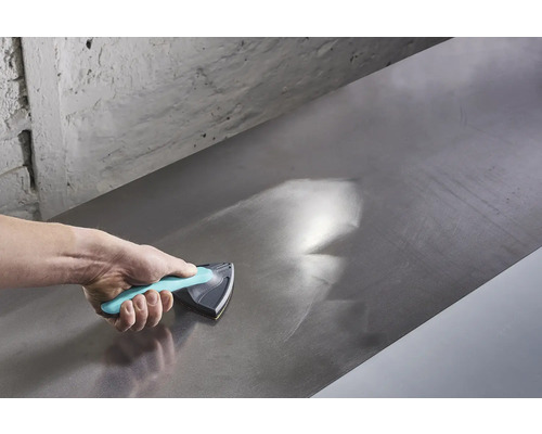 Hand nutzt Schleifklotz zum Glätten einer Metalloberfläche.