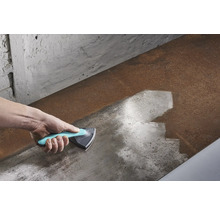 Hand mit Dreiecksschaber beim Reinigen einer Metalloberfläche