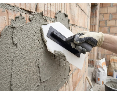 Verputzen einer Ziegelwand mit einer Glättkelle