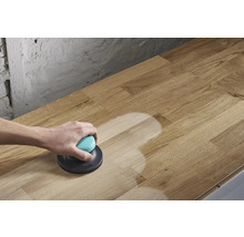 Eine Person schleift eine Holzplatte mit einem Exzenterschleifer.