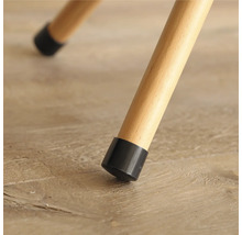 Detailansicht eines Stuhlbeins mit schwarzem Bodenschoner auf einem Holzboden