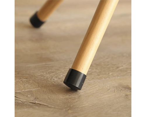 Detailansicht eines Stuhlbeins mit schwarzem Bodenschoner auf einem Holzboden