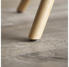 Nahaufnahme eines Möbelbeins aus Holz mit Bodenschoner.