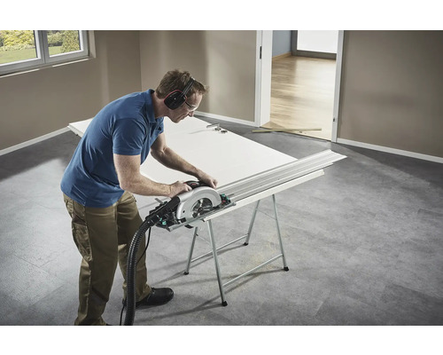 Handwerker sägt eine Tür mit einer Handkreissäge auf einer Werkbank.