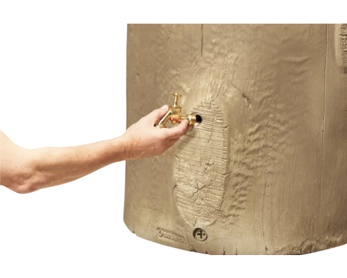 Eine Hand montiert einen Auslaufhahn aus Messing an eine Regentonne in Holzoptik.