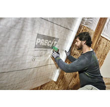 Mann befestigt variable Dampfbremsfolie von Precit mit einem Tacker im Innenbereich.