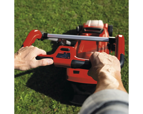 Eine Person bedient einen Rasenmäher auf einer Rasenfläche.