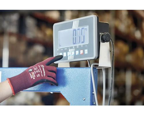 Eine Person bedient eine digitale Industriewaage mit einem Arbeitshandschuh