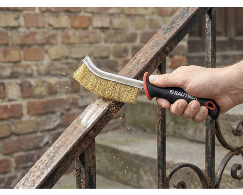 Eine Hand benutzt eine Drahtbürste zur Metallreinigung auf einem Geländer. Rautner Logo sichtbar.