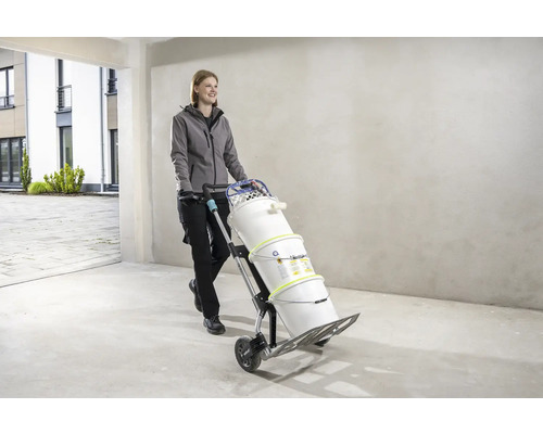 Frau transportiert Farbeimer mit einer Sackkarre.