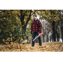 Mann mit Akku-Laubbläser im herbstlichen Garten