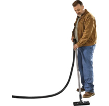 Mann saugt mit einem Staubsauger