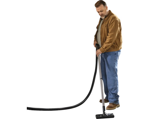 Mann saugt mit einem Staubsauger