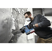 Ein Mann entfernt Fliesen mit einem Bohrhammer von Bosch.