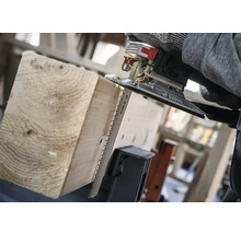 Eine Stichsäge schneidet ein Holzbrett.