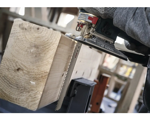 Eine Stichsäge schneidet ein Holzbrett.