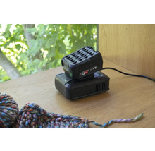 Akkupack und Ladegerät für Elektrowerkzeuge auf einem Tisch.