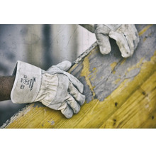 Ein Arbeiter trägt Gebol Worker Schutzhandschuhe bei der Arbeit mit einem Holzrahmen.
