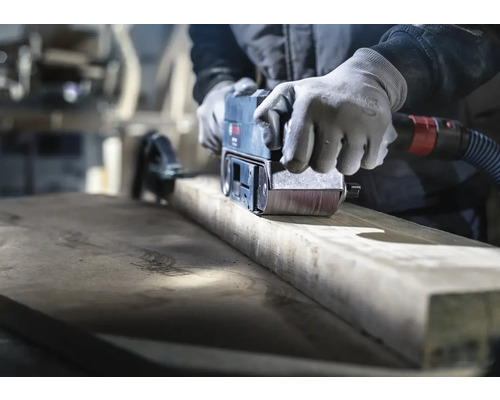 Handwerker schleift Holz mit einem Bandschleifer