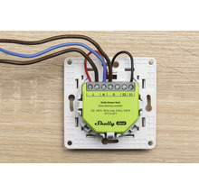 Shelly Dimmer Gen4 Smart-Dimm-Controller in weißem Montagerahmen mit angeschlossenen elektrischen Leitungen für die Unterputzmontage.