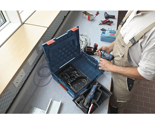 Handwerker mit Werkzeugkoffer und Akkuschrauber