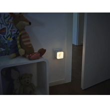 Smarter Zwischenstecker mit integriertem Nachtlicht in einer Wandsteckdose in einem Kinderzimmer.