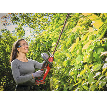 Frau schneidet Hecke mit Akku-Heckenschere von Einhell