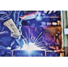 Schweißer bei der Arbeit mit Schweißausrüstung und Handschuhen