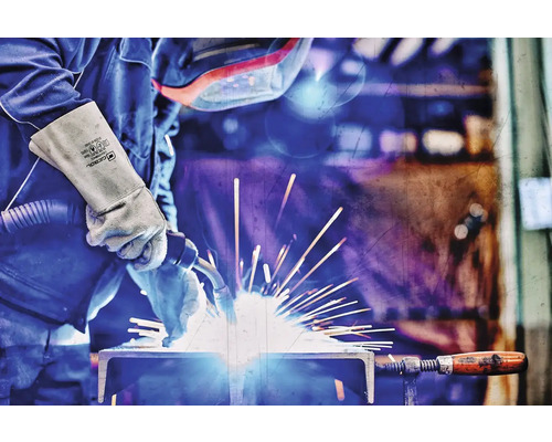 Schweißer bei der Arbeit mit Schweißausrüstung und Handschuhen