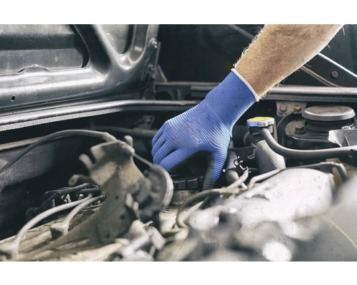 Eine Hand mit Schutzhandschuh inspiziert einen Automotor.