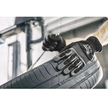 Eine Person mit Arbeitshandschuhen hält einen Reifen.