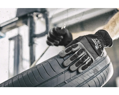 Eine Person mit Arbeitshandschuhen hält einen Reifen.