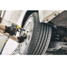 Ein Mechaniker wechselt ein Rad mit einem Schlagschrauber.