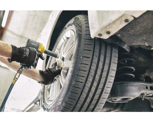 Ein Mechaniker wechselt ein Rad mit einem Schlagschrauber.