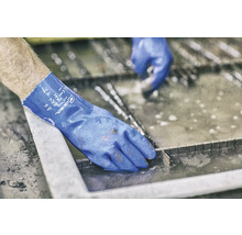 Eine Person trägt Gebol Blue Tech Arbeitshandschuhe.